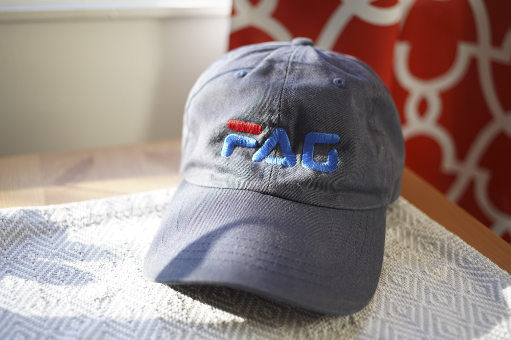 Photograph of a baseball hat that says, 'FAG' in a popular logo style.